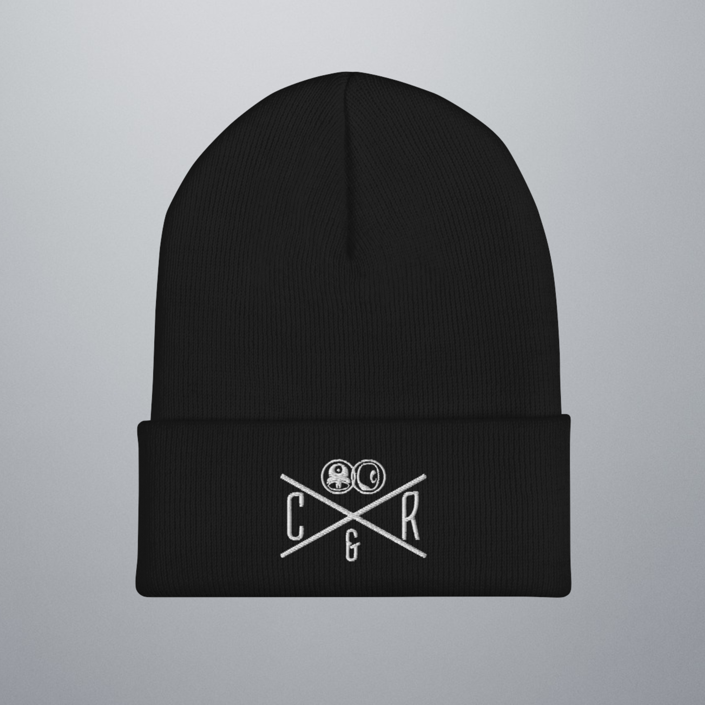 Beanie, Winterstrickmütze in Schwarz mit gesticktem Logo-Design. Ein X-Muster teilt das Design in vier einzelne Bereiche. Rechts ist ein C, Links ein R, Oben das Logo (Sprühcap im Kreis und eine Skateboard-Rolle im Kreis), unten das Und-Zeichen. Auf diesem Bild ist die Mütze flach liegend.