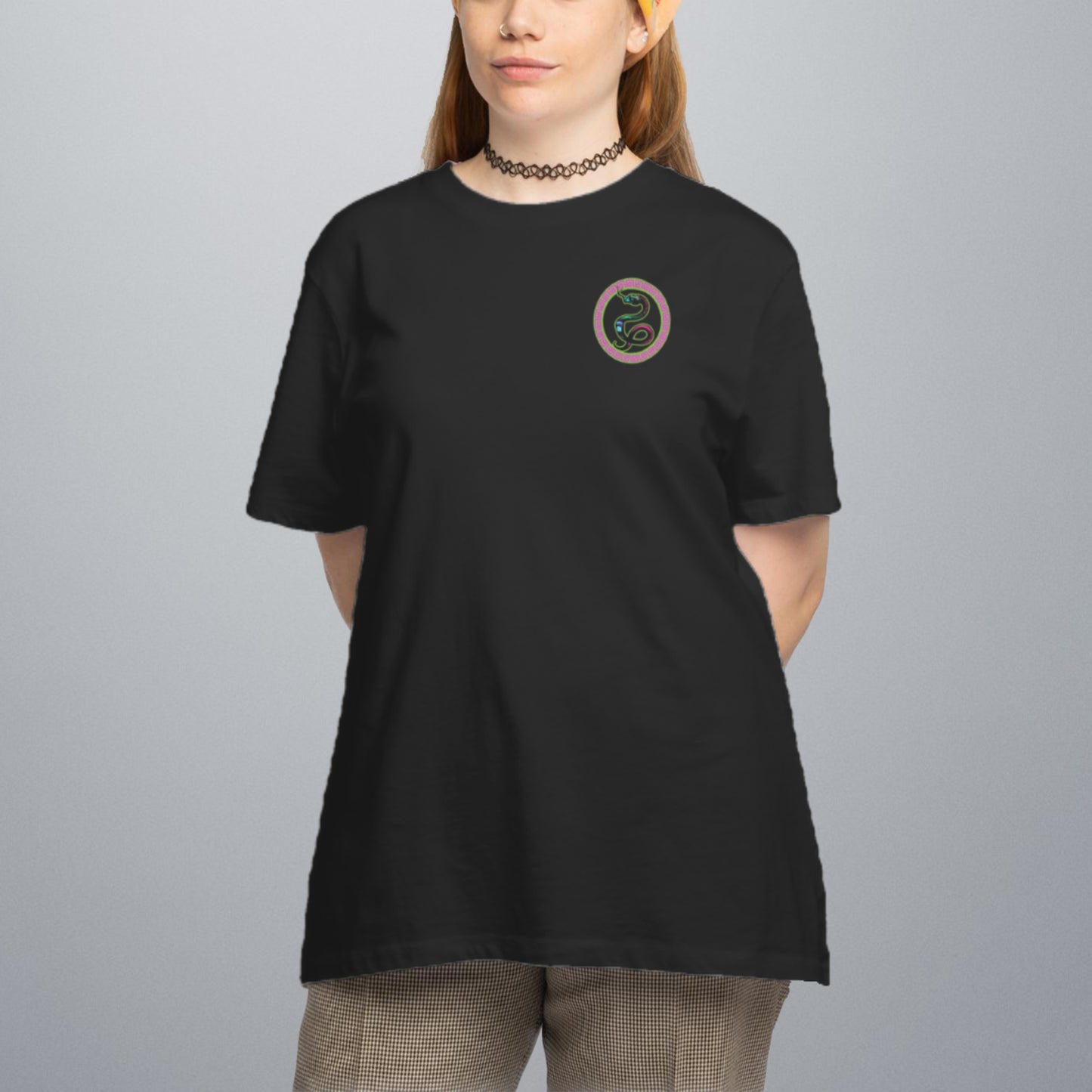 Dieses Bild zeigt einen Frau mit dem T-Shirt Medusa von vorn. Das T-Shirt ist schwarz und auf der linken Brust ist eine Schlange in einem Kreis.